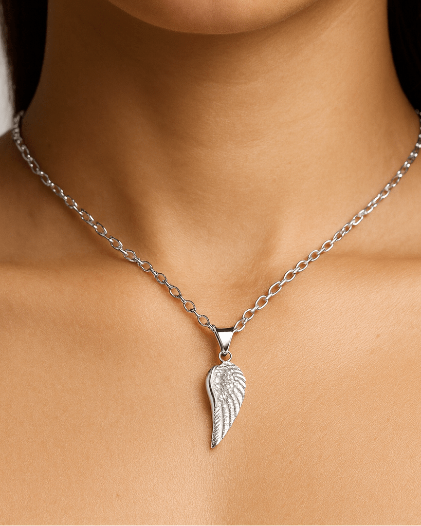 Close-up of a person wearing a silver necklace with an angel wing pendant urn.