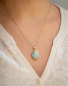 Cara Keepsakes Gold Locket Urns Gold Filigree Oval Locket Urn worn on model