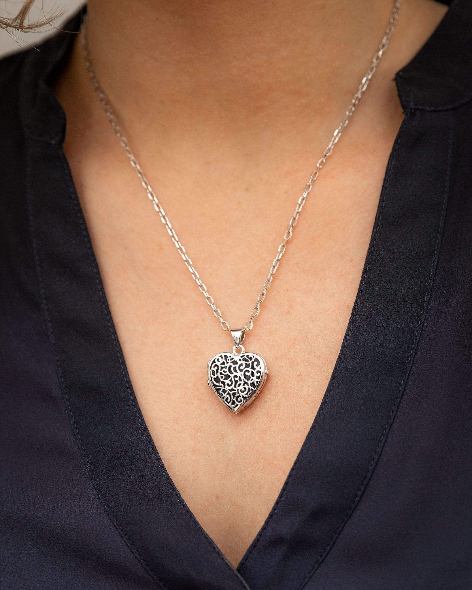 silver heart filigree locket urn on woman's neck