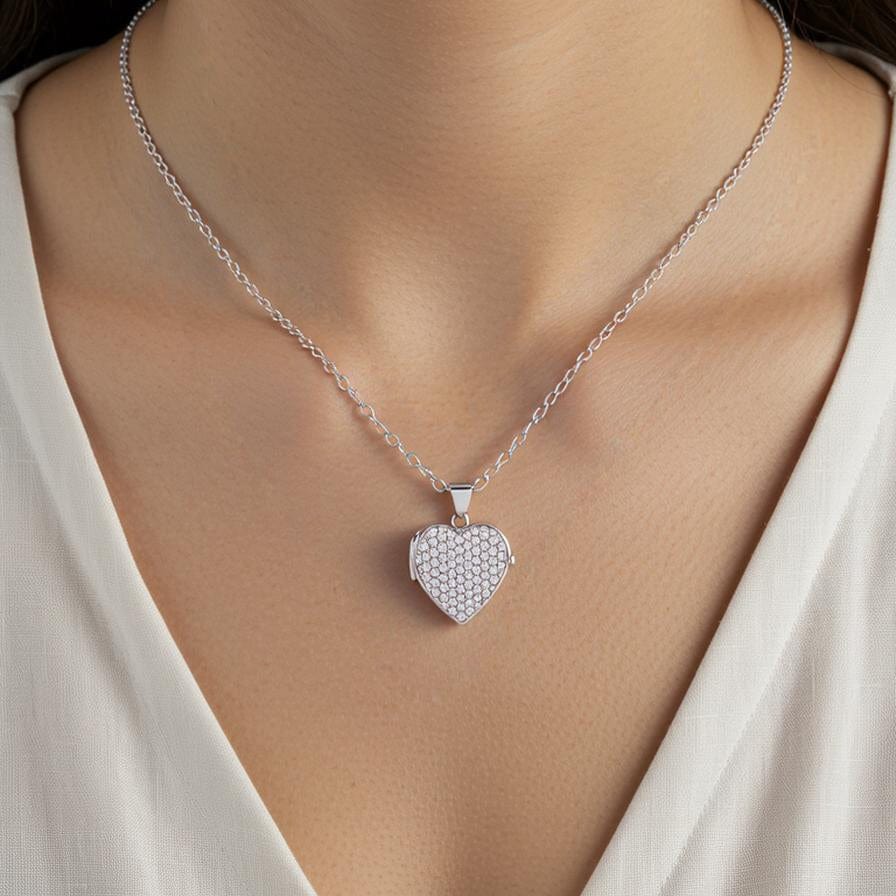 Silver heart-shaped pendant necklace on a model wearing a white top.